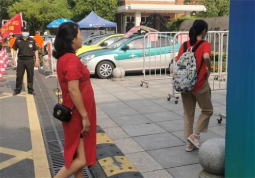 杭二中考点， 穿红旗袍的家长送女儿进考场.png
