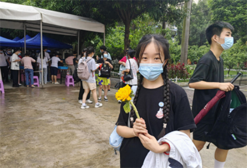 【南宁沛鸿民族中学桃源校区考点】南宁九中考生拿着班主任赠送的寓意一举夺魁的葵花。.png