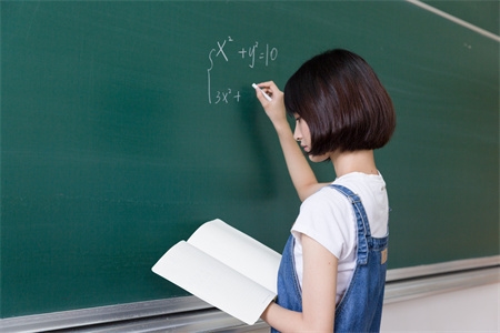 摄图网_500557450_正在教室黑板写板书的女生（企业商用）.jpg