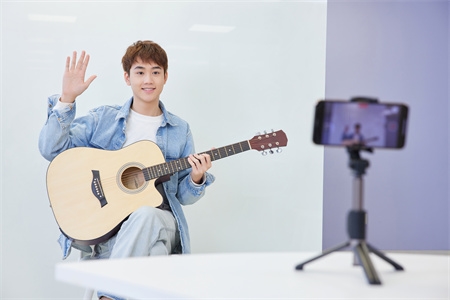 摄图网_501893040_青年男性手机直播弹奏吉他（企业商用）.jpg